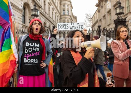 7 décembre 2019. Westminster, Londres, Royaume-Uni. Les activistes LGBTQ+ manifestent devant les portes de Downing Street à Londres à l'approche des élections générales britanniques de 2019. La manifestation répond à l’utilisation par le premier ministre Boris Johnson d’un langage désobligeant, y compris des insultes homophobes. Les manifestants arborent des drapeaux arc-en-ciel, des pancartes et des slogans tels que « BUM BOYS against Boris Johnson », exigeant des comptes et un leadership inclusif. La manifestation met en lumière la résistance queer à la rhétorique discriminatoire dans la politique britannique. Penelope Barritt/Alamy Live News Banque D'Images