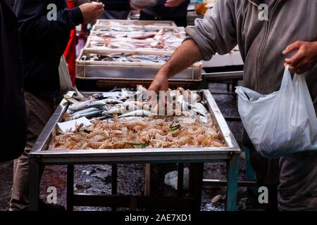 Catane, Italie - AVRIL 26 : Vendeur à côté de son étal de poisson mer vente cigales dans la rue Marché aux poissons, sur le 26 avril, 2019 Banque D'Images