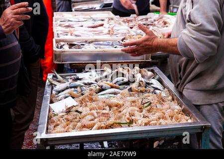 Catane, Italie - AVRIL 26 : Vendeur à côté de son étal de poisson mer vente cigales dans la rue Marché aux poissons, sur le 26 avril, 2019 Banque D'Images