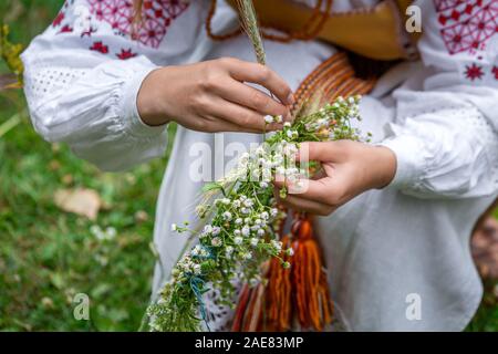 Faire des couronnes en biélorusse vêtements traditionnels, la célébration de la fête de l'Kupalle païenne, le midsummer festival marquant le début de l'été à Banque D'Images