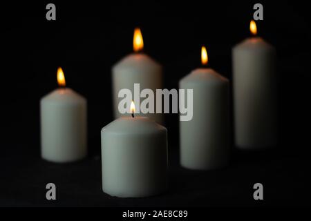 Cinq témoins lumineux d'une flamme lumineuse gravure bougie sur fond noir Banque D'Images