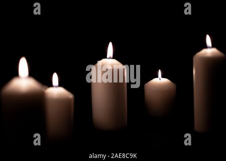 Cinq témoins lumineux d'une flamme lumineuse gravure bougie sur fond noir Banque D'Images