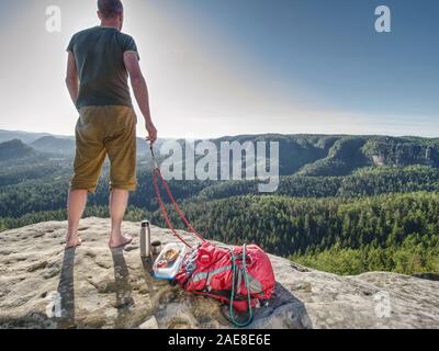 L'âge moyen guy petit-déjeuner sur le sommet rocheux. Sports et motivation thème. Beau temps, mauvais temps. Banque D'Images