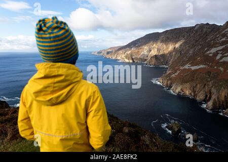 Jeune garçon à la recherche de l'océan au Slieve League cliffs de Bunglass, comté de Donegal, Irlande Banque D'Images