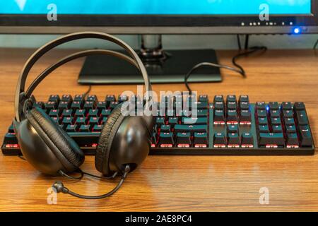 Clavier rétroéclairé noir et casque sur une table en bois Banque D'Images