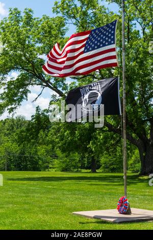 Le drapeau américain et POE / MIA drapeau flotte au vent à un cimetière de Memorial week-end à Humansville, Missouri. Banque D'Images