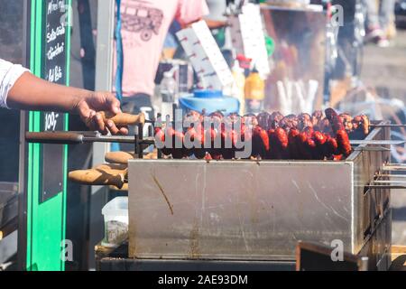 Et saucisses chorizo poulet rôti sur un charbon Spit barbecues torréfacteur Banque D'Images