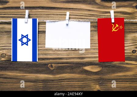Drapeaux suspendus d'Israël et l'Union soviétique attaché à corde avec pinces à linge avec de l'espace de copie sur papier blanc sur fond de bois.e diplomatique Banque D'Images