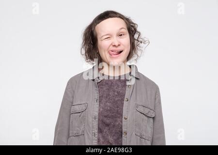 Pretty caucasian girl sticking out tongue, taquiner quelqu'un, ayant regard amusant. Du visage positif l'émotion humaine. Banque D'Images