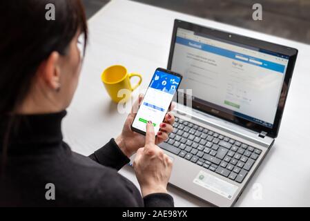 Sarajevo, Bosnie-Herzégovine - décembre 7, 2019 : utilise un téléphone mobile et un ordinateur portable pour le réseau social Facebook Banque D'Images