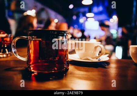 Thé rouge dans un verre sur le comptoir du bar en bois. Arrière-plan flou Banque D'Images