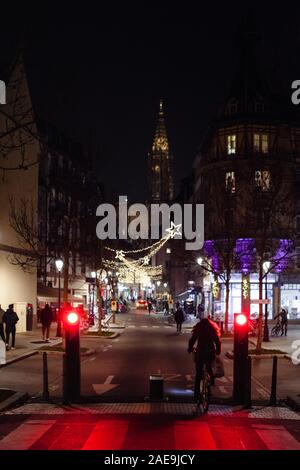 Strasbourg, France - Dec 20, 2016 : scène de nuit Strasbourg entrée cycliste avec le marché de Noël illuminé et rue Notre-Dame de la cathédrale de Strasbourg avant la clôture de sécurité de la tour de la rue piétonne Banque D'Images