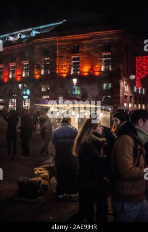 Strasbourg, France - Dec 20, 2016 : Nuit image de l'homme vente de marrons chauds châtaignes grillées et les piétons personnes découvrant le marche de Noel Marché de Noël Banque D'Images