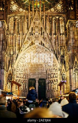 Strasbourg, France - Dec 20, 2016 : Grande foule avec vue arrière du jeune homme shoulers sur père avec Notre-Dame de la cathédrale de Strasbourg en arrière-plan lors de marché de Noël Banque D'Images