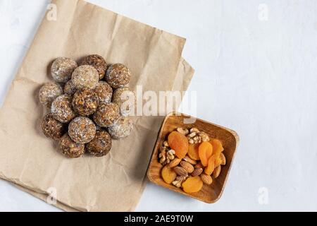 Des boules d'énergie avec les abricots secs, les raisins secs, les dattes, les pruneaux, noix, amandes et noix de coco. Une saine. Mise à plat, vue du dessus. Banque D'Images