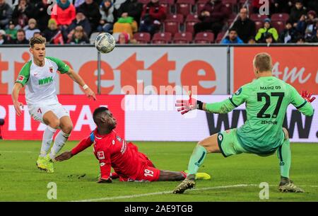 Augsburg, Allemagne. 7 Décembre, 2019. Florian Niederlechner (L) d'Augsbourg prend un coup dans la défense de Moussa Niakhate (C) de Mayence au cours d'un match de Bundesliga allemande entre FC Augsburg et 1.FSV Mayence 05 à Augsburg, Allemagne, le 7 décembre 2019. Crédit : Philippe Ruiz/Xinhua/Alamy Live News Banque D'Images