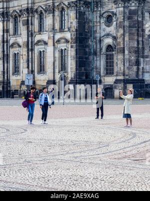 Les touristes chinois prenant des photos à Theaterplatz et à la cathédrale Kayholische Hofkirche de la Sainte Trinité Altstadt Dresde Saxe Allemagne. Banque D'Images