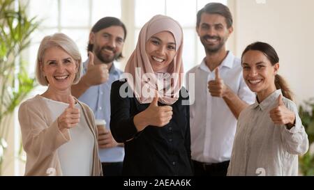 Head shot portrait of smiling groupe multiracial showing Thumbs up. Banque D'Images