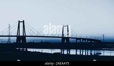 Silhouette de la suspension grand pont en béton, près de Figueira da Foz, Portugal. Couleur de l'année 2020 dans les tons bleus classique Banque D'Images