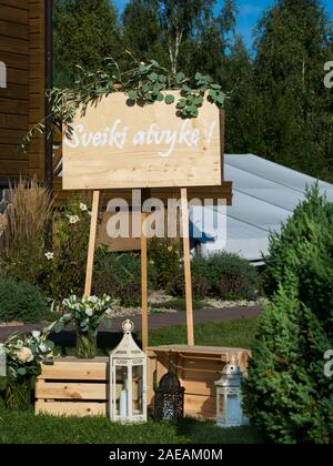 Un panneau à l'entrée de la salle de mariage dire 'Bienvenue' à l'eucalyptus et des bougies décorées Banque D'Images