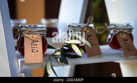 Les petits pots de verre remplis de miel, décorées à l'eucalyptus et une écriture attachée à eux en disant "Merci" Banque D'Images
