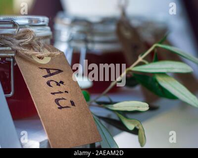 Les petits pots de verre remplis de miel, décorées à l'eucalyptus et une écriture attachée à eux en disant "Merci" Banque D'Images