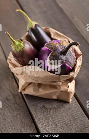 Aubergines bio zéro déchets en sac de papier sur bois Banque D'Images