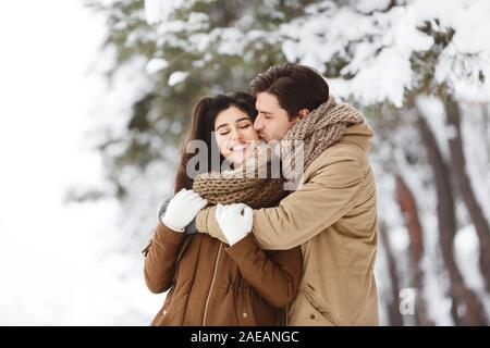 Ma copine au couple Hugging joue dans la forêt enneigée Banque D'Images