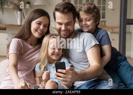 Les familles avec enfants à l'aide d'avoir du plaisir à la maison du smartphone Banque D'Images