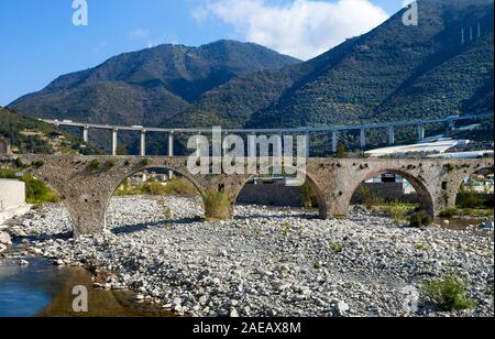 Vieux pont médiéval en pierre sur l'Argentine river, derrière le viaduc de Taggia, Taggia, ligurie, italie Banque D'Images