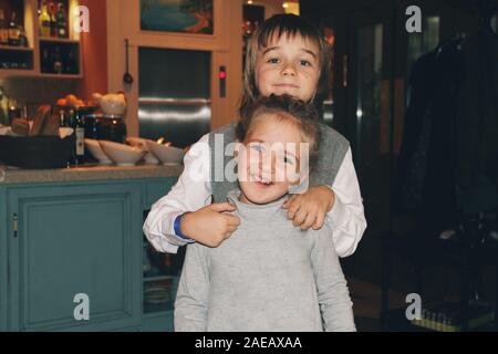 Portrait de petite fille et garçon de race blanche dans les tenues de serrant. Cute amis ou frère et soeur ressemble à la maison de rêve. Enfance heureuse, l'art, Banque D'Images