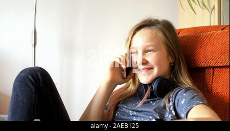 Fille utilise la technologie moderne. Petite fille jouant sur un téléphone cellulaire. L'enfant passe son temps libre avec la technologie moderne. Banque D'Images