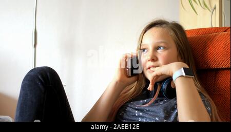 Fille utilise la technologie moderne. Petite fille jouant sur un téléphone cellulaire. L'enfant passe son temps libre avec la technologie moderne. Banque D'Images