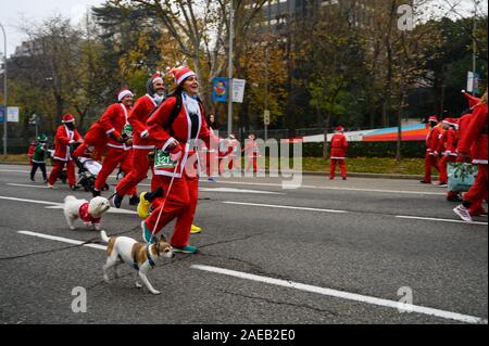 Madrid, Espagne. 8 Décembre, 2019. Des gens habillés en Père Noël en marche avec leurs chiens pendant la course de Noël annuelle du Père Noël. Credit : Marcos del Mazo/Alamy Live News Banque D'Images