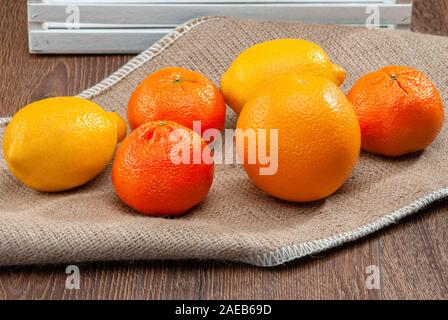 Oranges et citrons tourné sur de la toile de jute close-up light de derrière Banque D'Images