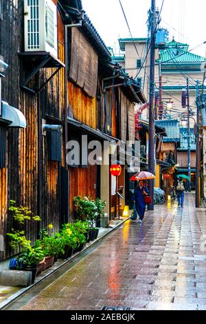 Un jour pluvieux à Kyoto, des gens avec des parasols marchant dans une rue dans le quartier de Gion Geisha, au Japon Banque D'Images