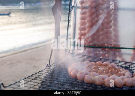 Griller les saucisses sur un gril de barbecue avec de la fumée blanche Banque D'Images