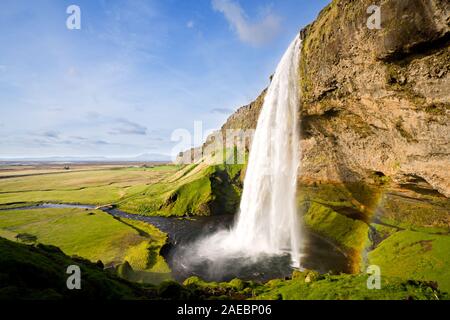 Cascade et paysage comme dans un rêve, l'arc-en-ciel avec de légères de Seljalandsfoss en Islande. Banque D'Images