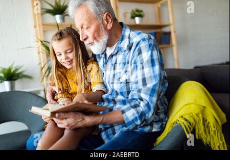 Grand-père barbu et son petit-fils ont du plaisir de lire un livre ensemble Banque D'Images