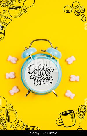 Réveil bleu avec texte et graphiques Coffee Time sur un fond jaune Banque D'Images