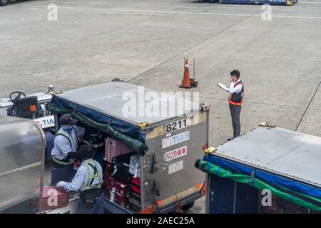 Le déchargement des bagages de l'avion dans l'Aéroport International de Taoyuan Banque D'Images