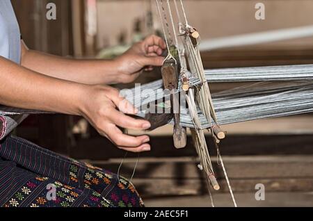 Avec une navette de tissage sur un métier à tisser traditionnel style Lao-Thai, Ban Phanom, Laos Banque D'Images