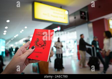 Portrait de femme tenant un passeport à l'aéroport de Singapour Banque D'Images