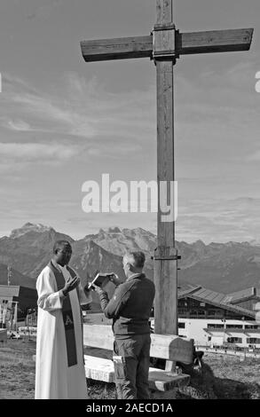 Cérémonie religieuse sur la montagne au-dessus de la ville de Schruns Hochfirst dans la vallée de Montafon avec un prêtre de l'Ouganda Banque D'Images