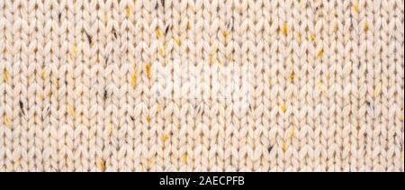 La texture de tissu beige tricot laine entrecoupées de fil jaune. Voir Portrait fond chandail Banque D'Images