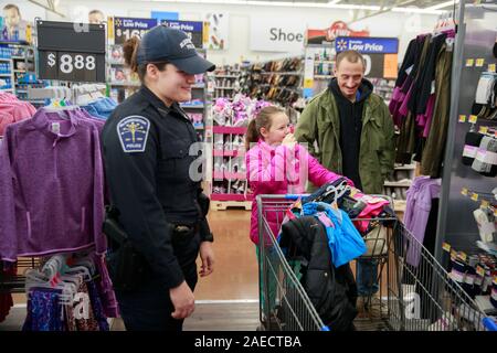 Bloomington Policier Jennifer Stevens, gauche, boutiques avec Gracie Livingston, centre, et son père, Livingston Jad boutique au cours d'une conférence, le dimanche 8 décembre 2019 à Bloomington, Ind. des membres des forces de l'ordre de comté de Monroe dont des membres de la Police de Bloomington, IUPD, Monroe County Sheriff's Office, et Département de Police de Ellettsville a participé à l'événement organisé par le Don Owens Memorial Fraternal Order of Police Lodge 88. (Photo de Jeremy Hogan/l'Bloomingtonian) Banque D'Images