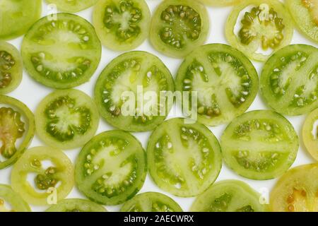 Solanum lycopersicum. Tranches de tomates vertes, vert sur fond blanc. Banque D'Images