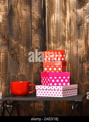 Tasse de café ou thé rouge ou céramique mug pour boire assez doux et boîtes présente le bac noir sur fond de bois, copy space Banque D'Images