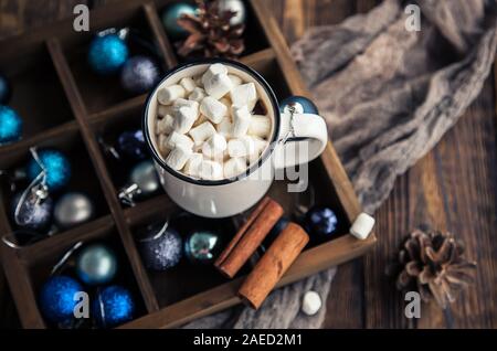 Tasse de café et de la guimauve et le bleu des boules de Noël sur fond de bois. Carte de vacances d'hiver Banque D'Images