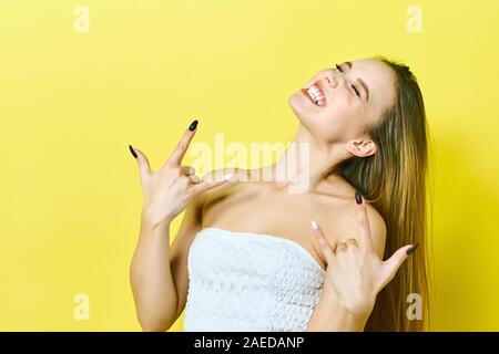 Parti trop jeune. Amoureux de la musique rock concept. La photo en gros plan portrait de heureux gai comique drôle funky lady faire stick out sign Banque D'Images